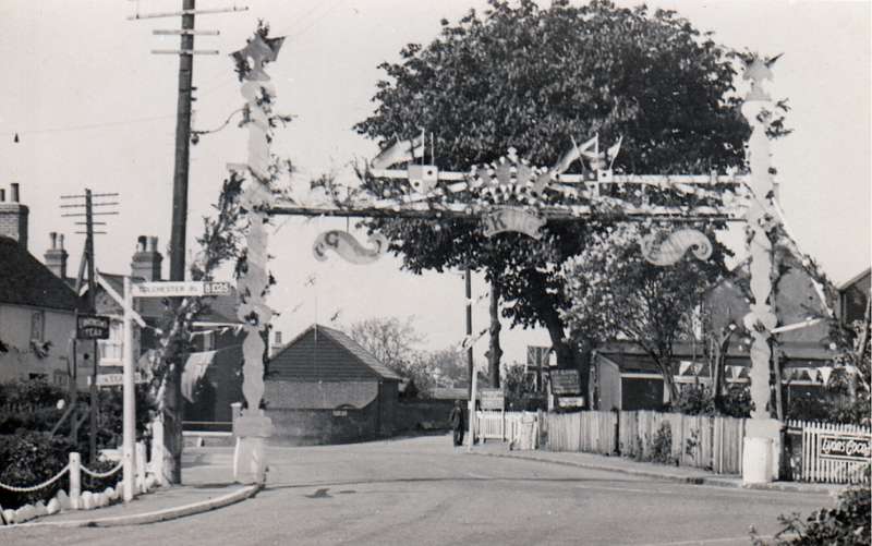  Jubilee Arch at Queens Corner. Upland Road in the distance with the blacksmith shop on the corner. 
Cat1 Mersea-->Events Cat2 Mersea-->Shops & Businesses Cat3 Mersea-->Road Scenes