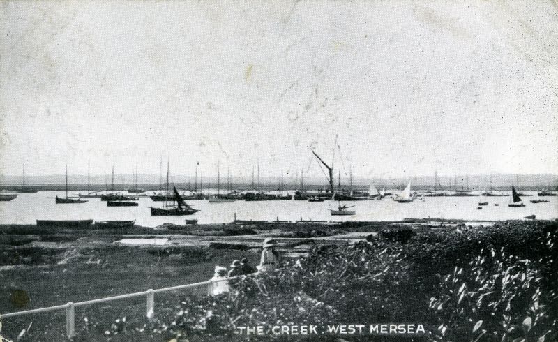  The Creek, West Mersea - a post card view along Coast Road. The barge dressed overall and a line of boats suggest it is Regatta Day.

Postcard from E T W Dennis No. 063675, mailed 7 March 1917. 
Cat1 Mersea-->Coast Road Cat2 Mersea-->Regatta-->Pictures