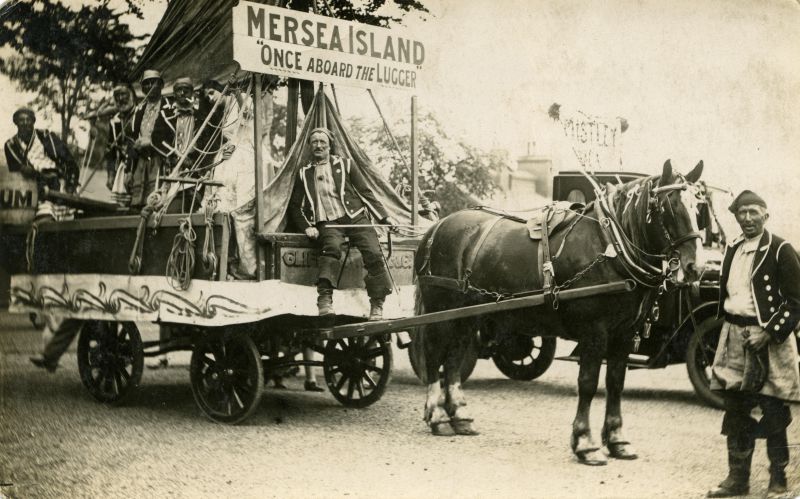 Click to Pause Slide Show


 Mersea Island entry winnner in Colchester Carnival Cup competition. Once aboard the lugger. Coal cart from Clifford White & Co., driver Fred Cook. Mrs Connie Mole (now Mrs C. Clarke) next to the mast. William Wyatt is in the middle of the group on the cart. Arthur Wade on the right, standing with the horse. 
Cat1 Mersea-->Events Cat2 Transport - buses and carriers Cat3 Families-->Mole