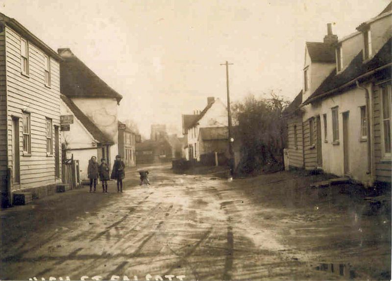  Salcott - the street. Ponder's butcher's shop on the right. The Sun Inn on the left in the distance. 1920s ? 
Cat1 Places-->Salcott & Virley
