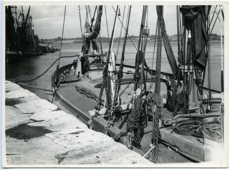  XYLONITE steel barge at Mistley. [DW]

Foredeck of a working barge. The XYLONITE at Mistley Quay, 1947. This photograph shows in detail the hand windlass, the foresail sheet horse of wood, mast case (tabernacle), rigging screws at the lower ends of the shroulds, the leeboard chocks at the bulwarks, the kedge anchor by the main hatch, the furled 'staysail' and foresail, and many other details ...
Cat1 Barges-->Pictures Cat2 Places-->Mistley