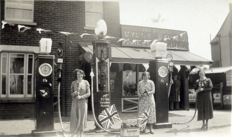  Mersea Cycle Stores. A.H. Cornelius. Petrol 1s 4d or 1s 6d a gallon. Kingsland Road, West Mersea.

Decorated for the 1953 Coronation ?

The pump in the centre is not electric and has to be wound by hand. 
Cat1 Families-->Cornelius Cat2 Mersea-->Shops & Businesses