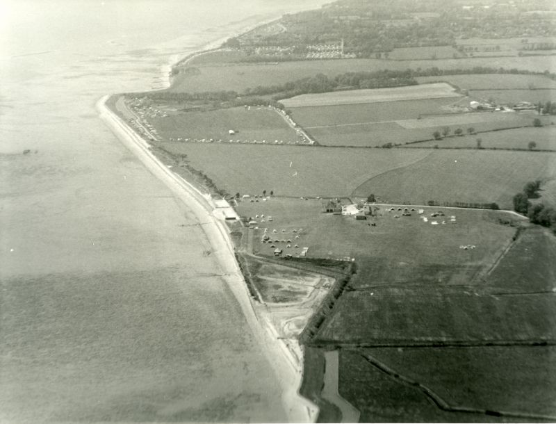  Jack Botham aerial photograph 3105. Looking west from above Coopers Beach, East Mersea. Just below centre is the Youth Camp, formerly Kiddiesland and currently (2018) Essex Outdoors. Decoy point is near the top, and beyond that Seaview Avenue can just be seen. 
Cat1 Aerial Views-->Mersea Cat2 Mersea-->East Cat3 Mersea-->Youth Camp