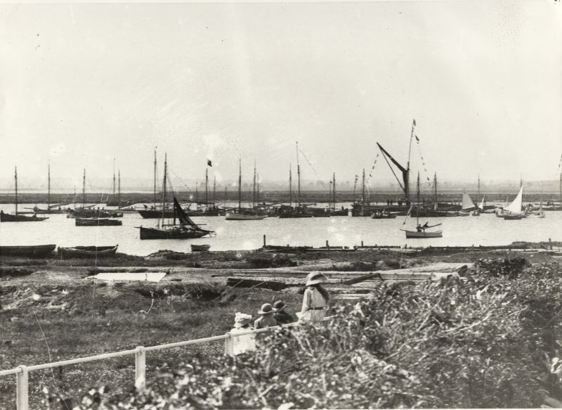  From a postcard The Creek, West Mersea - a view along Coast Road. The barge dressed overall and a line of boats suggest it is Regatta Day. 

Also published by Mersea Museum as a postcard. 
Cat1 Mersea-->Regatta-->Pictures