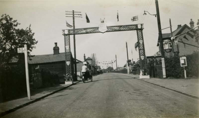  Ancient Order of Foresters arch over Barfield Road for the Jubilee. A.O.F. Salutes the Sailor King on the shield. The ice cream man is cycling through the arch. 
Cat1 Mersea-->Events Cat2 Mersea-->Road Scenes