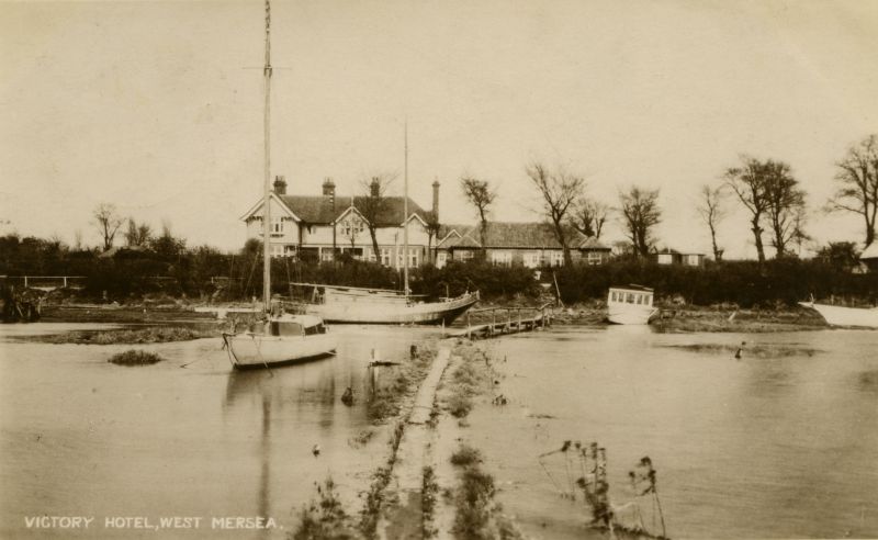  Victory Hotel, West Mersea, from houseboats. Dutch yacht in front of hotel. The Victory Dance Hall can be seen on the east side of the hotel.

Postcard mailed 6 September 1929 to Miss Muriel Smith, Scarborough. 
Cat1 Mersea-->Pubs Cat2 Mersea-->Houseboats