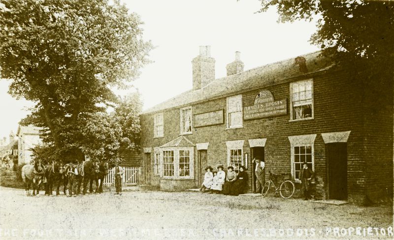  Old Fountain East Road. Tom Saye & Frank Hyham with horses. The girls on the bench are Dolley Green, Gertie Lilley, Georgie Boggis & sister Empsie. Mr Boggis landlord. Charles Boggis, who ran the Pub stands in the doorway whilst his son, George, poses in front of the window. The Fox can just be seen on the extreme left.

The names were written on the back of the card by Dolly Green who gave ...
Cat1 Mersea-->Pubs Cat2 People-->Other