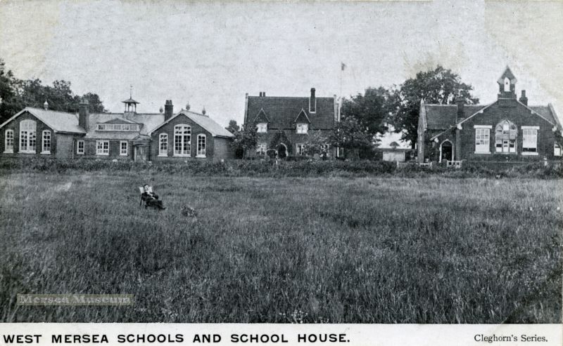  West Mersea Schools and School House. Cleghorn Series postcard. The gentleman sitting in the deck chair in the field would now be in the middle of the Co-op store. Cleghorn was most active 1902 - 1908, so photograph probably dates from this period. 
Cat1 Mersea-->Schools-->Pictures