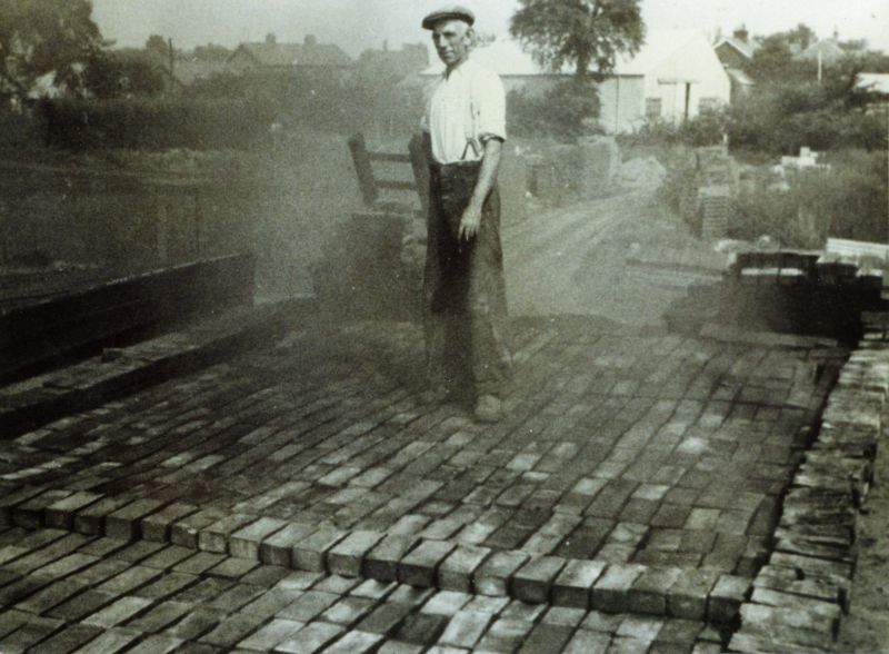  Brickmaker Bill Gasson about to unload the kiln. Mersea brickyard - Underwoods Garage in background. 
Cat1 People-->Other Cat2 Mersea-->Shops & Businesses