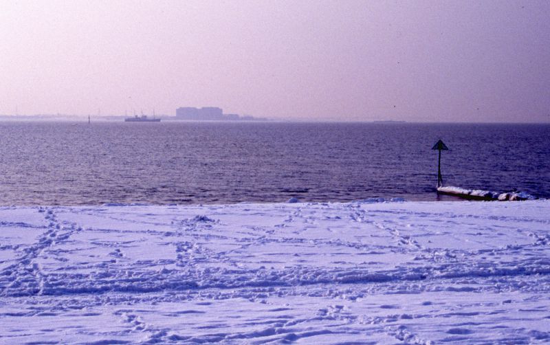 Bradwell Power Station across the Blackwater from a snowy Kingsland Beach. Trinity House SIREN laid up in the river. Date: cFebruary 1991.