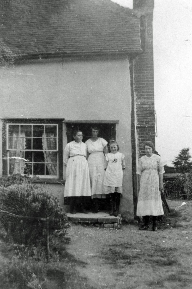  Whiting Family at Games Farm, Lower Road, Peldon. The picture is from the north west corner - door behind the family is now blocked off.
From left to right are Anna Whiting, Rhoda, Ruth and Beatrice.



Anna Whiting née Sheldrick [grandmother of Tony Baldwin] was born in 1872 and died 2 Aug 1934 aged 62. She was married to George William Whiting born 1861, died 6 Apr 1922 aged 61. ...
Cat1 Places-->Peldon-->People Cat2 Places-->Peldon-->Buildings