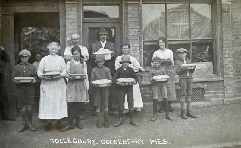  Gooseberry Pies

A feature of village life which became connected to the annual Fair during the last weekend of June, were the Gooseberry Pies. They were slow-cooked overnight in Sunderland clay dishes sold to local women by the bargemen. Some entries are proudly displayed here outside Shynn's bakery in North Road. 'Tollesbury Past by Keith Lovell, figure 71. 
Cat1 Tollesbury-->Events