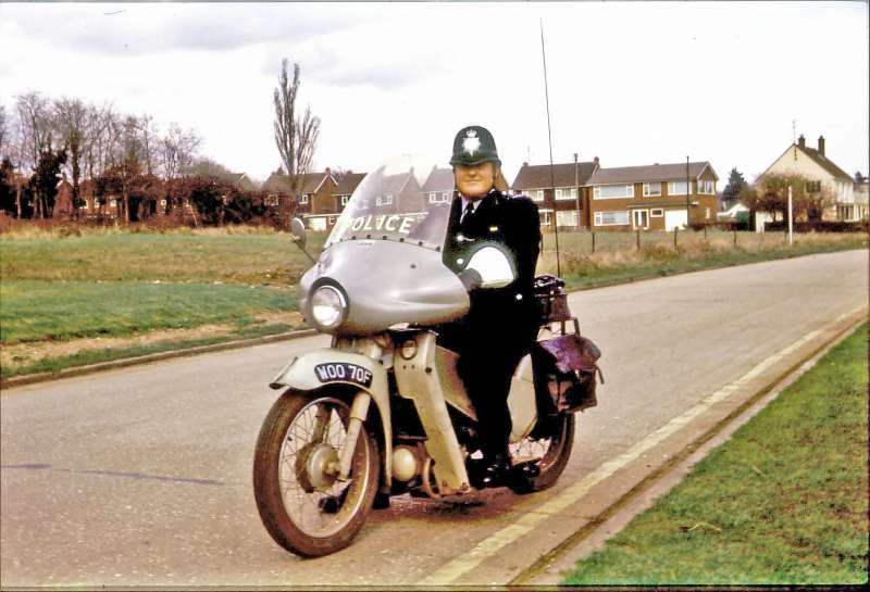  PC Ron Beckwith on Victoria Esplanade, West Mersea. The houses in the background are in Empress Avenue - the field to the left is now Orchid Field Flats.



The Police motorcycle is WOO70F, first registered 1968-69. The Velocette LE bikes were nicknamed 'Noddy Bikes' and had a water cooled four-stroke engine. 
Cat1 Mersea-->Road Scenes