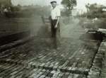  Brickmaker Bill Gasson about to unload the kiln. Mersea brickyard - Underwoods Garage in background.  RG19_151