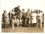  Mr Charles Scott being carried by two bathers after landing at the Golf Course. Barbara Mears is on the left with Bob Munro next to her. Charles Scott's first wife is just right of centre - wearing a coat.
 The bather on the left of the picture is Mr Frank French from Brightlingsea - did he swim across or come on the ferry ? He was a local milkman in Brightlingsea.
</p>
<p>C.W.A. Scott was a famous aviator who held a number of records for flying between England and Australia in the 1930s. He was a Mersea resident for some time and a member of West Mersea Yacht Club and the Golf Club. He was a good yachtsman and owned the yawl CHAMELEON which he kept locally.
</p><p>
Charles Scott was born in Westminster in 1903. He learned to fly in the RAF in 1922, but in 1926 left the RAF and emigrated to Australia where he was a commercial pilot in the early years of the company that is known today as Qantas. He was a complex and colourful character, married 3 times, and died in 1946 by suicide.
</p>
<p>See wikipedia for a detailed biography of Charles Scott.</p>  BS01_033